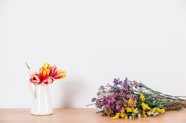 Arranged tulips and wildflowers on table