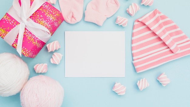 Arrangement of baby clothes and postcard