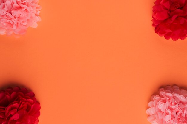 Arrangement of beautiful origami paper flower over orange surface