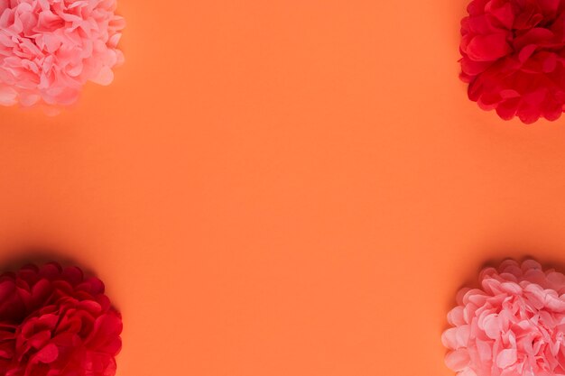 Композиция из красивого оригами бумажного цветка на оранжевой поверхности