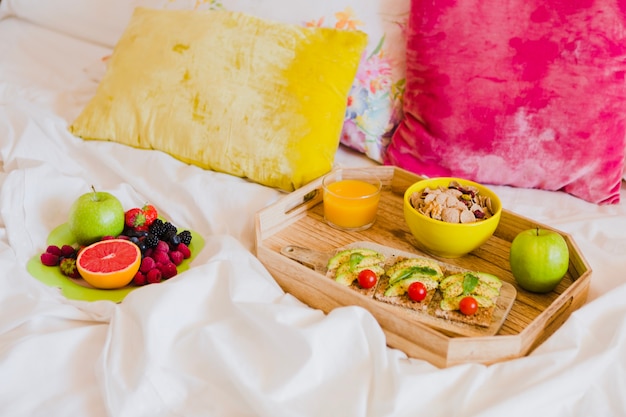 Arrangement of breakfast on bed