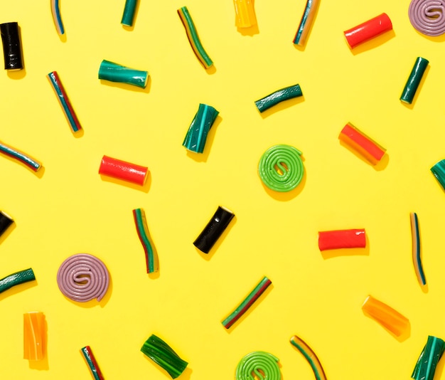 Arrangement of candies on yellow background