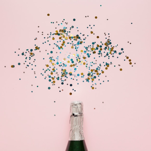 Arrangement of champagne bottle and colourful confetti