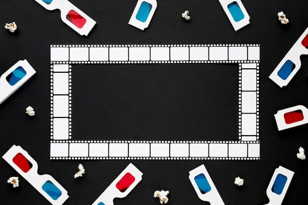 Arrangement of cinema elements on black background with film frame