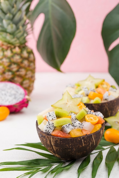 Free photo arrangement of coconuts filled with fruit salad