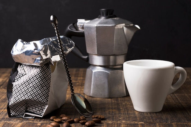 Arrangement of coffee grinder with sack and mug front view