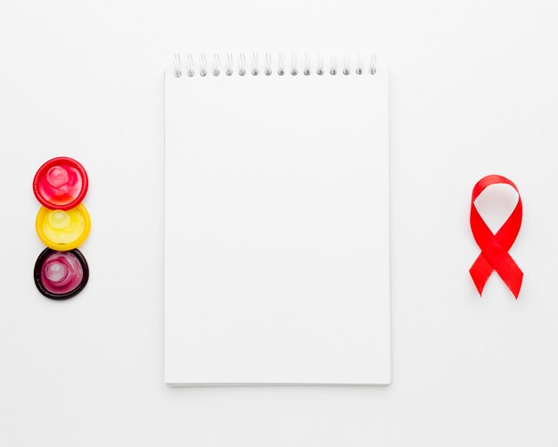 Arrangement of colorful condoms with empty notepad