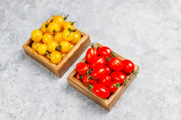 Arrangement of colorful fresh assorted tomatoes on concrete surface