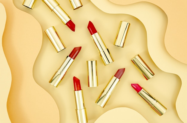 Arrangement of colorful lipsticks with abstract background