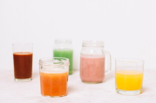 Arrangement of colorful smoothies with white background