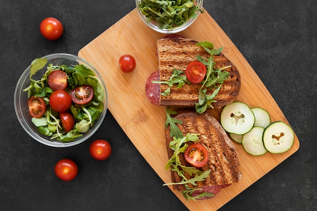 Arrangement of delicious sandwiches on wooden board