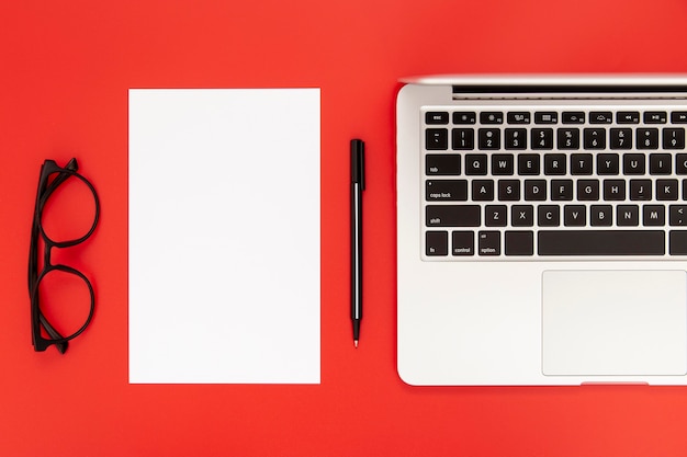 Arrangement of desk elements on red background