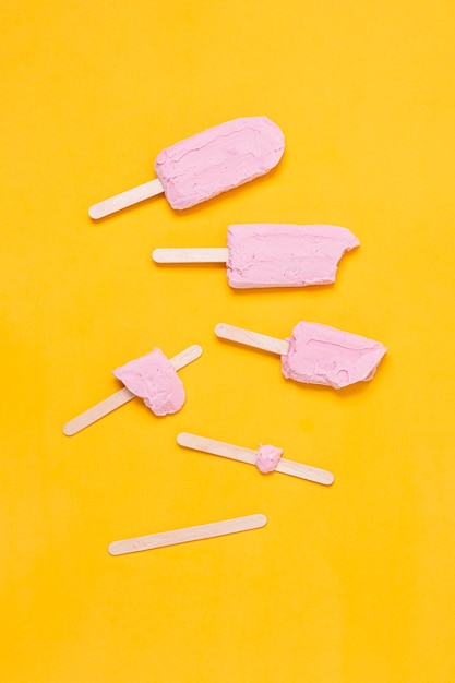 Композиция плоской укладки этапов розового мороженого на палочке