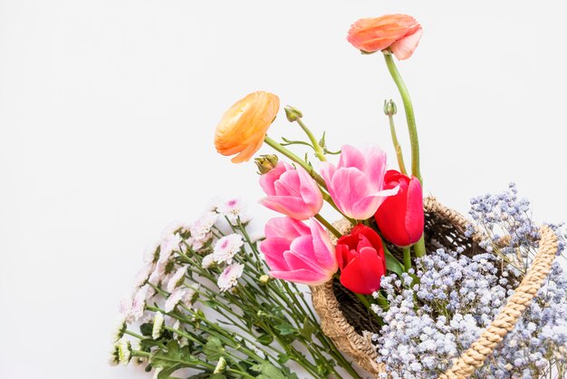 Arrangement of flowers in basket on white background