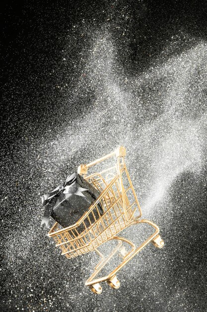 Arrangement of golden shopping cart with white glitter