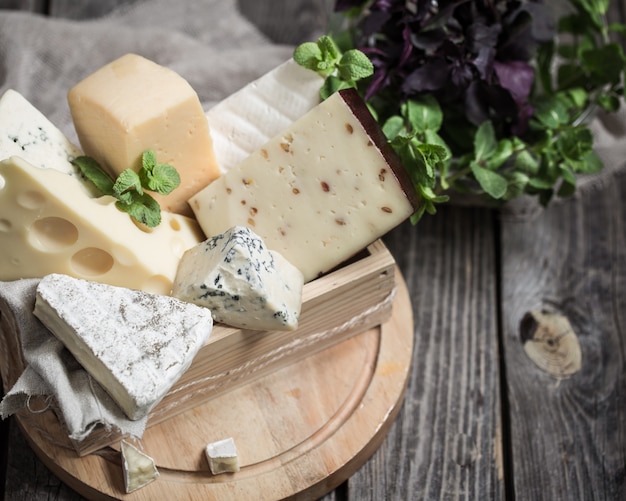 Free photo arrangement of gourmet cheese on wooden background,concept of gourmet cheeses