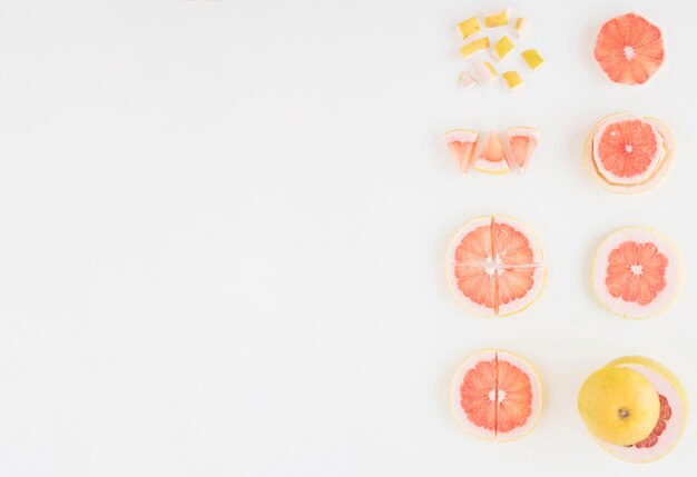 Композиция из грейпфрута нарезать разными ломтиками на белом фоне