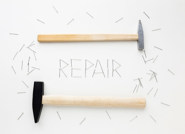 Free photo arrangement of hammers and repair word written with nails