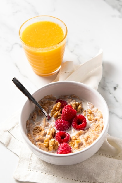 Foto gratuita disposizione dei cereali sani ciotola con succo d'arancia