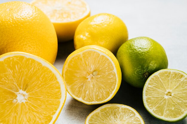 Arrangement of lemons and limes on plain background