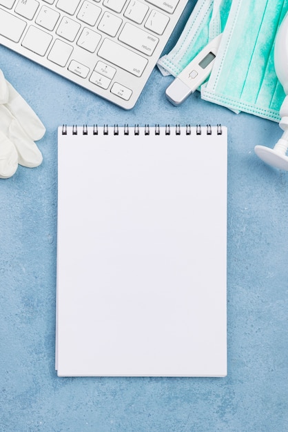 Arrangement on medical desk with empty notepad