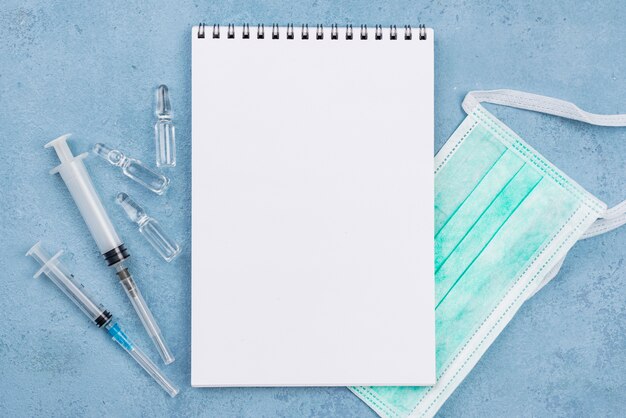 Arrangement of medical objects with empty notebook