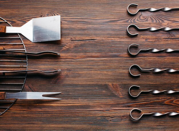 Arrangement of new barbecue utensil set over wooden surface