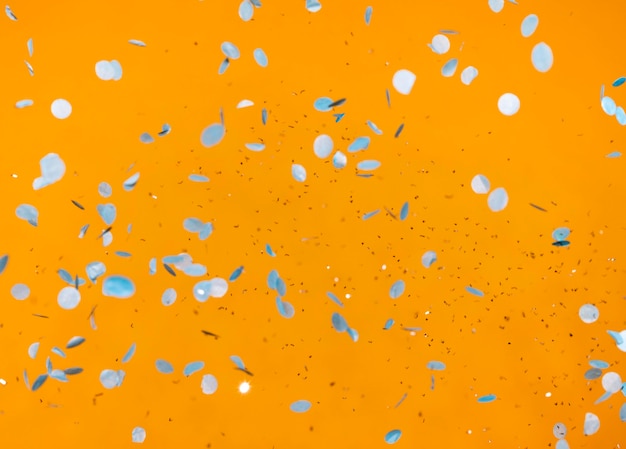 Arrangement of party confetti on orange wall