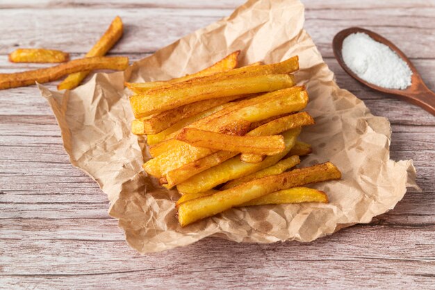 Arrangement of potato fries on wooden background