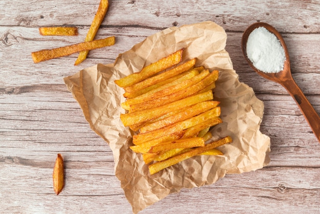 Arrangement of potato fries on wooden table