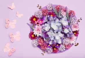 Foto gratuita disposizione dei bei fiori con sfondo viola