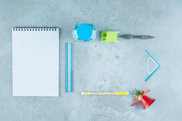 Arrangement of stationery products and a decorative bell on marble.