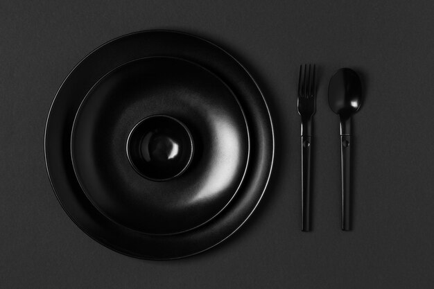 Arrangement of tableware on black background