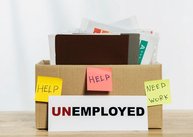 Композиция с коробкой и знаком безработных