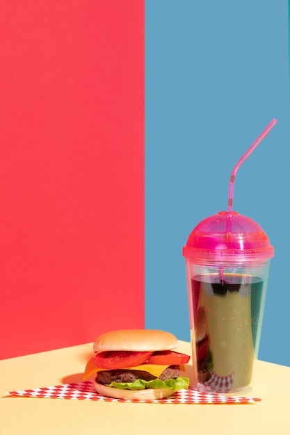 Arrangement with cheeseburger and tasty juice 