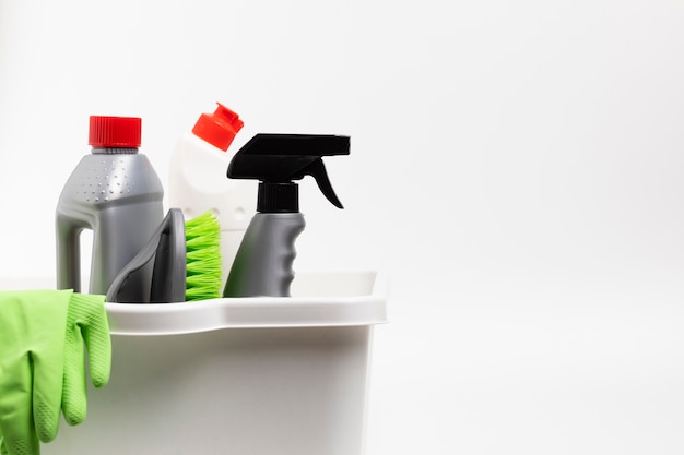 Arrangement with cleaning products and gloves in basin