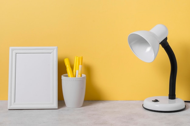 Arrangement with desk lamp and pens