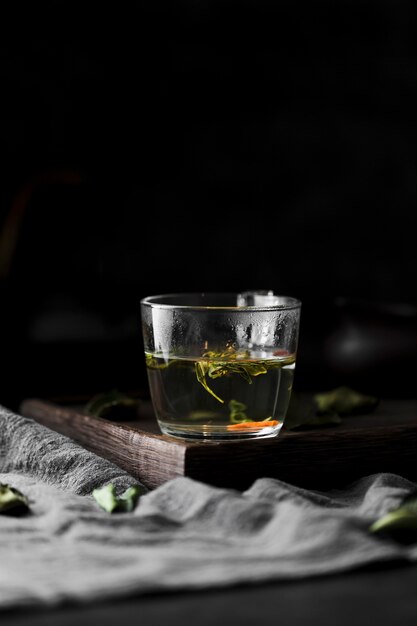 Arrangement with drink with herbs and dark background