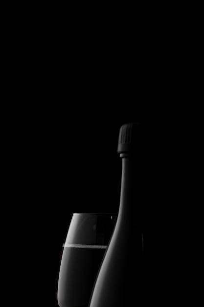 Arrangement with glass and bottle in the dark