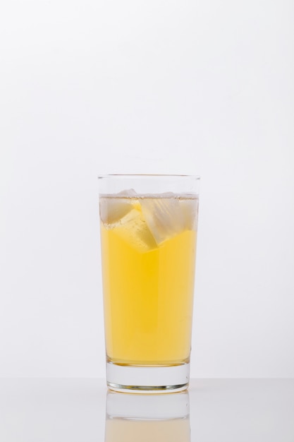 Arrangement with glass of drink and ice cubes