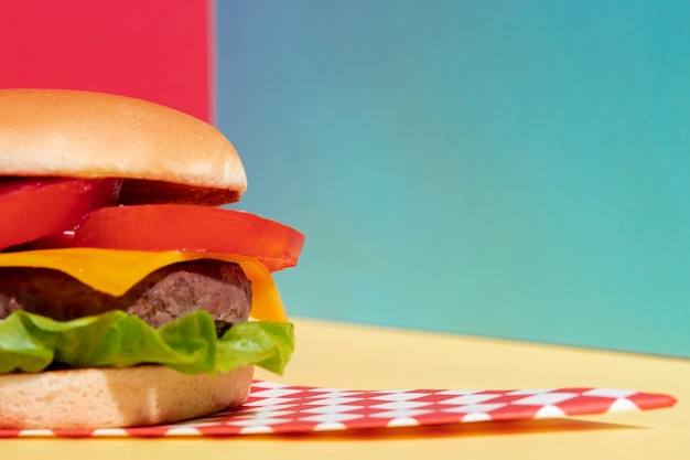 Arrangement with half cheeseburger on yellow table
