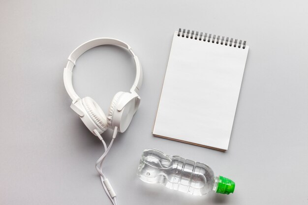 Arrangement with headphones, notebook and water bottle