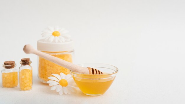 Arrangement with honey and salts on white background