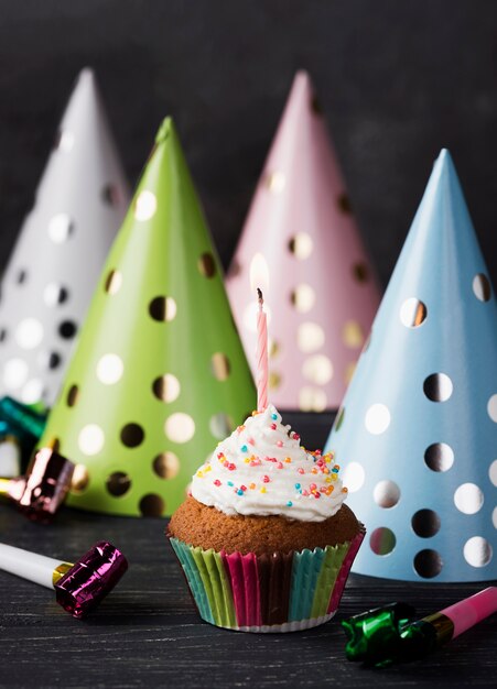 Arrangement with muffin and candle on wooden background