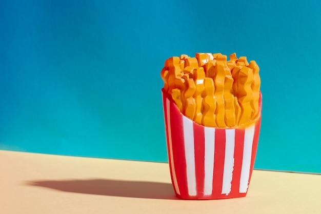 Arrangement with plastic fries and blue background