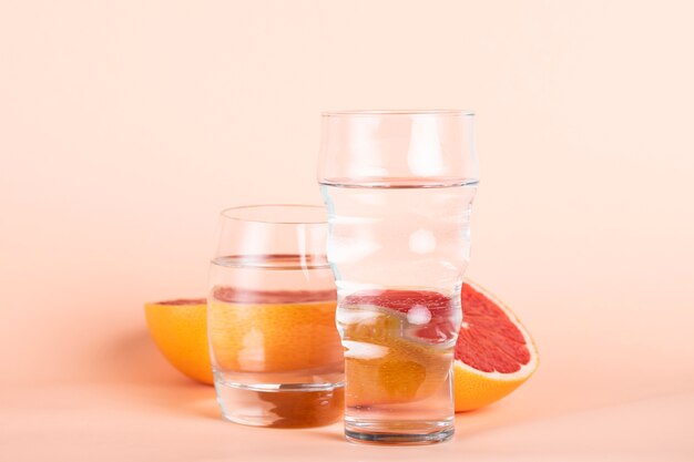 Композиция с красным апельсином и стаканами воды