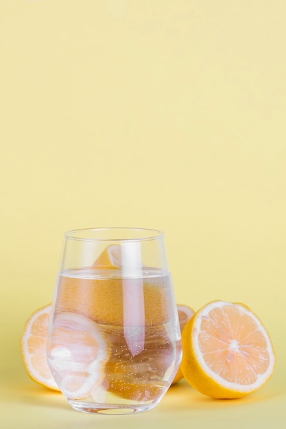 Arrangement with small glass of water and lemons