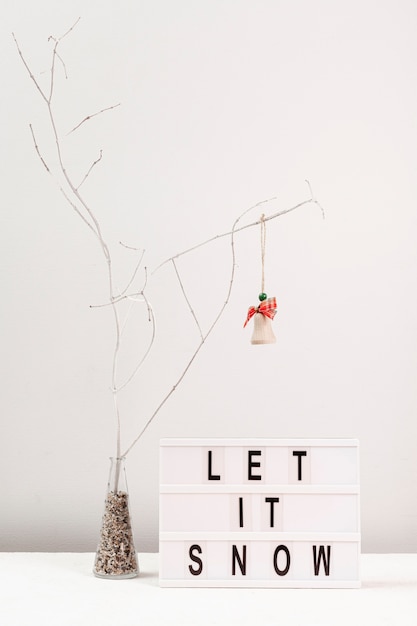 Arrangement with tree decoration and let it snow sign