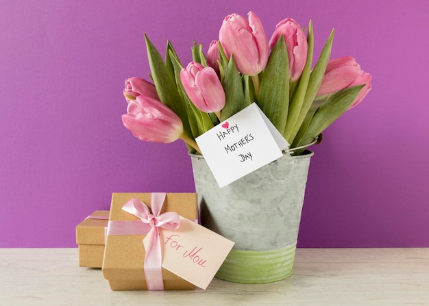 Бесплатное фото Композиция с тюльпанами и подарком