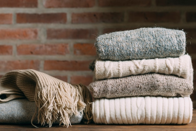 Arrangement with warm clothes and brick wall